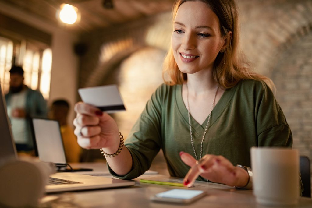 Smiling businesswoman making online payments with credit card an